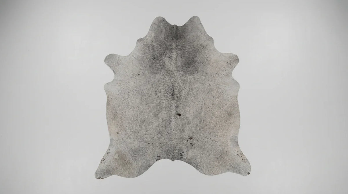 Grey cowhide rug flat lay on white background showing full hide shape