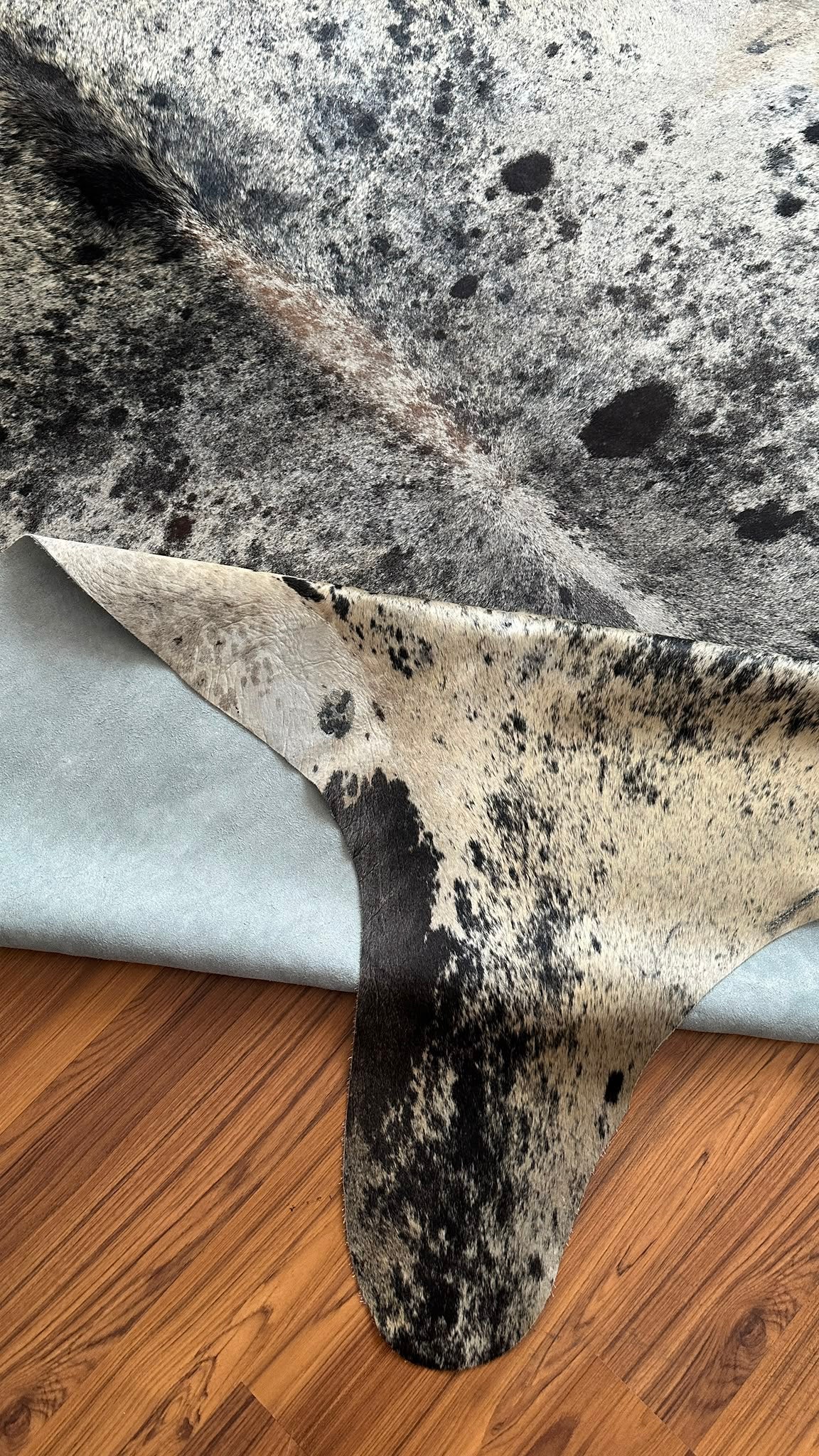 Close-up texture of Grey salt and pepper cowhide rug — Fine even speckle of dark and light hairs throughout, peppered appeara