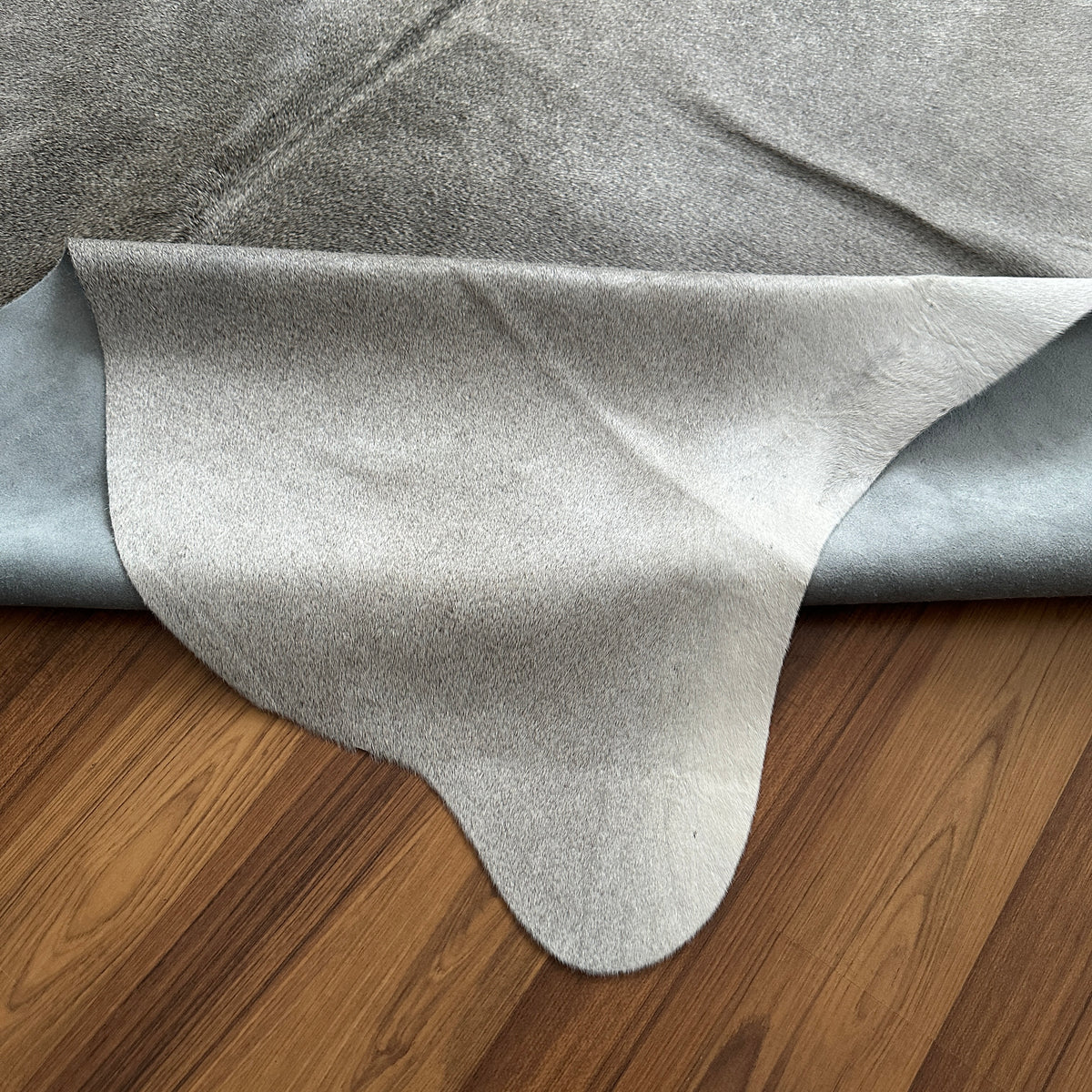 Close-up texture of Grey cowhide rug — Large irregular cream and grey patches with natural mottling over a pale base