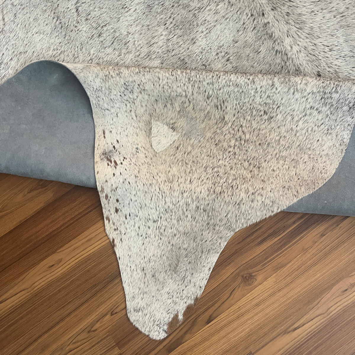 Close-up texture of Grey cowhide rug — Fine salt-and-pepper speckle throughout with darker concentrate along the spine