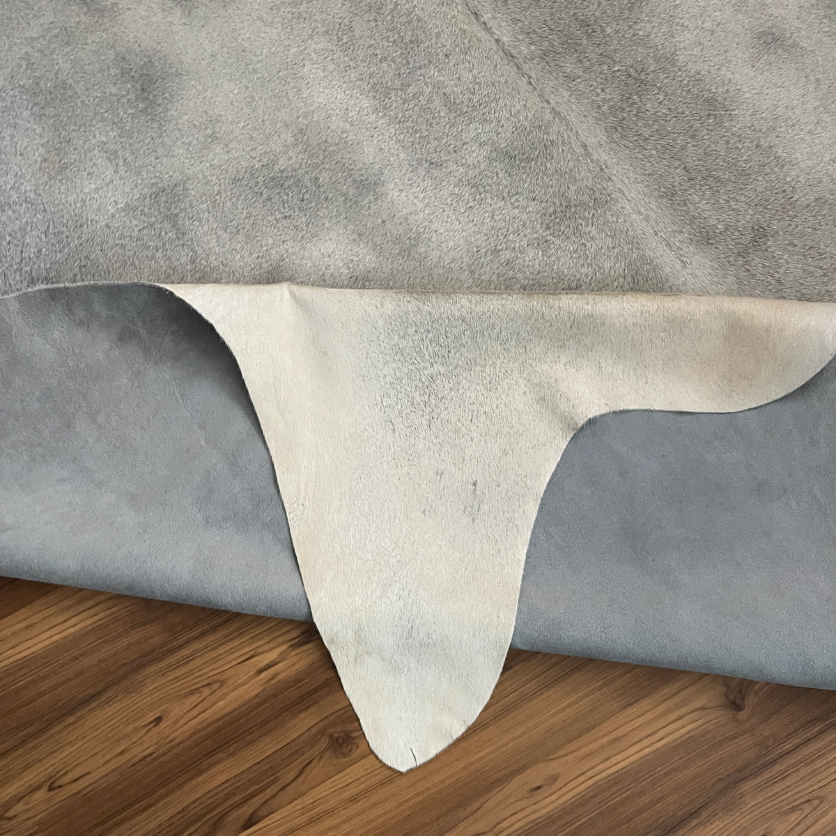 Close-up texture of Grey cowhide rug — Fine salt and pepper speckle with light grey base and darker charcoal markings
