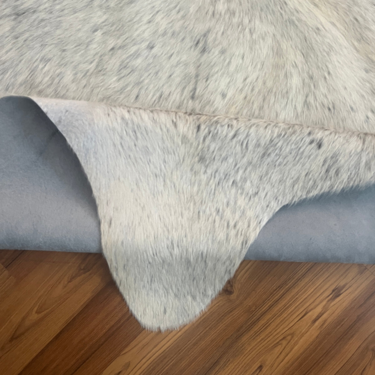 Close-up texture of Grey cowhide rug — Fine salt and pepper speckle with darker grey streaking along the dorsal line